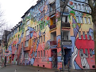 Blok domů na Kiefernstraße, roh Fichtenstraße pomalovali umělci z celého světa