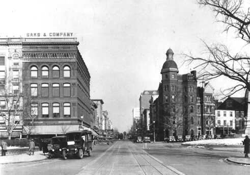 7th Street NW, nördlicher Blick von Pennsylvania Avenue, 1935. Mit den geschäftigen Straßenbahnlinien und dem dichten Verkehr ist das Geschäftsleben der 7th Street immer noch zu erkennen in dieser Era vor Vororten, Kriegen und Shoppingcenter. In der Ferne kann man den Turm des damals zukünftigen Marlo's Furniture Stores sehen, der an der Ecke der 7th und I Street in der Sonne leuchtet.