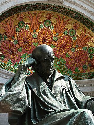 Four large bronze bas-relief panels on the walls surrounding the statue depict Hahnemann as a student surrounded by books, a chemist in the laboratory, a teacher in the lecture room, and a physician at the bedside. Hahnemann is seated on a pedestal centered in front of a curving wall. The pedestal bears the well-known principle of homeopathy, expressed in the Latin phrase 'similia similibus curantur' (like cures the like). The words 'Die milde Macht ist gross' (gentle power is great) are carved on the base of the memorial. (2000)