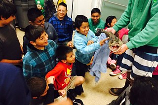 Kevin Butler, Fischer und Koch, zeigt Kindern einen Lengdorsch in ihrem Klassenzimmer.