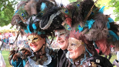 Besucher in barocken Kostümen.