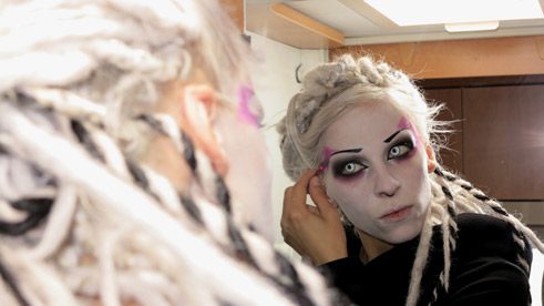 Niha schminkt sich in der Badekabine des Wohnwagens.