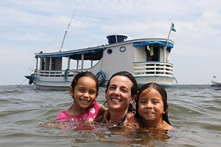 Meninas ribeirinhas e turista no rio Tapajós.