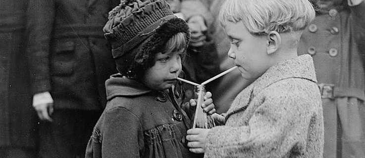 Zwei Kinder teilen sich ein Getränk
