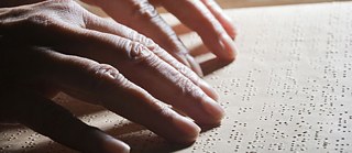 Blinde Menschen lesen mit den Fingern;