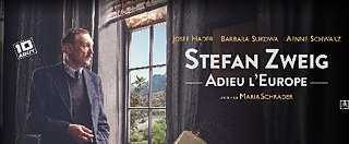 Stefan Zweig debout devant une fenêtre, vue sur un paysage brésilien