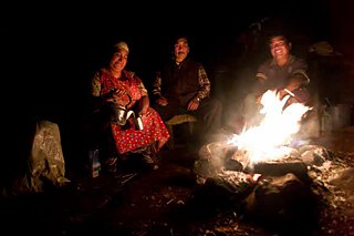 Die Pehuenche. Carmen gießt, am Herdfeuer sitzend, für die ganze Familie heißes Wasser auf die Mateblätter. Da wird Juan nach seinen Ratschlägen für das alltägliche Leben gefragt. 