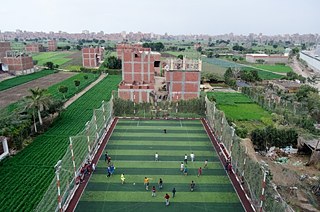 Die Nachbarschaft von Saft el-Laban und die Schüler von Mish Madrasa, die ihren Ausflug zu einem benachbarten Fußballfeld genießen. Die ländlichen Ursprünge der Nachbarschaft sind noch offensichtlich. 