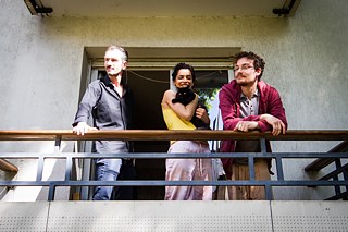 Zina Barrani (29 ans), Toussaint Boos (30 ans), étudiants, et Samuel Ramirez, vendeur de tableaux, sur le balcon de leur colocation