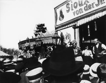 Audience in front of a fairground exhibit with Sioux Indians, 1900 
