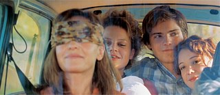 Quatre personnes dans une voiture dont une femme avec les yeux bandés
