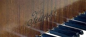 Keys and firm name on the front of the Kaps grand piano 