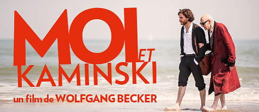 Werbeplakat des Films "Ich & Kaminski" mit einem älteren und einem jüngeren Mann, die eingehakt barfuss am Strand entlang laufen
