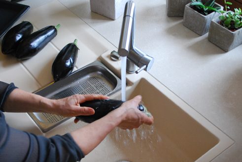 Die Auberginen waschen und mit einem Messer mehrmals einstechen. Auf einem Blech bei 200 °C ca. 20 Minuten garen. Mehrmals wenden. 