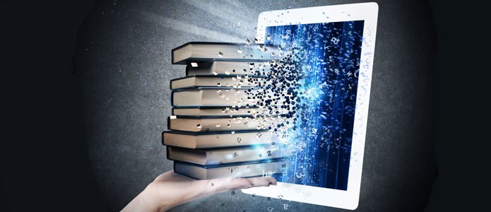 Eine Hand mit einem Bücherstapel vor einem Tablet