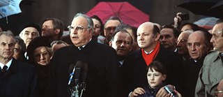 Helmut Kohl (hinter den Mikrofonen) während der Öffnung des Brandenburger Tors am 22. Dezember 1989 in Berlin