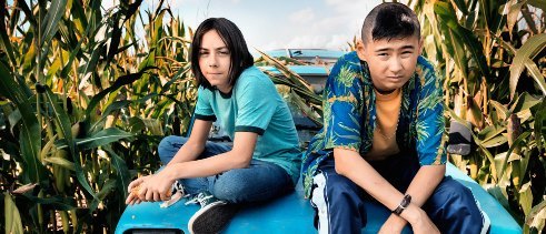 Goodbye Berlin, film still: two boys are sitting on the hood of their car