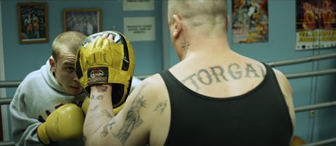A Heavy Heart, film still: two men in a boxing ring, one of them is heavily tattooed