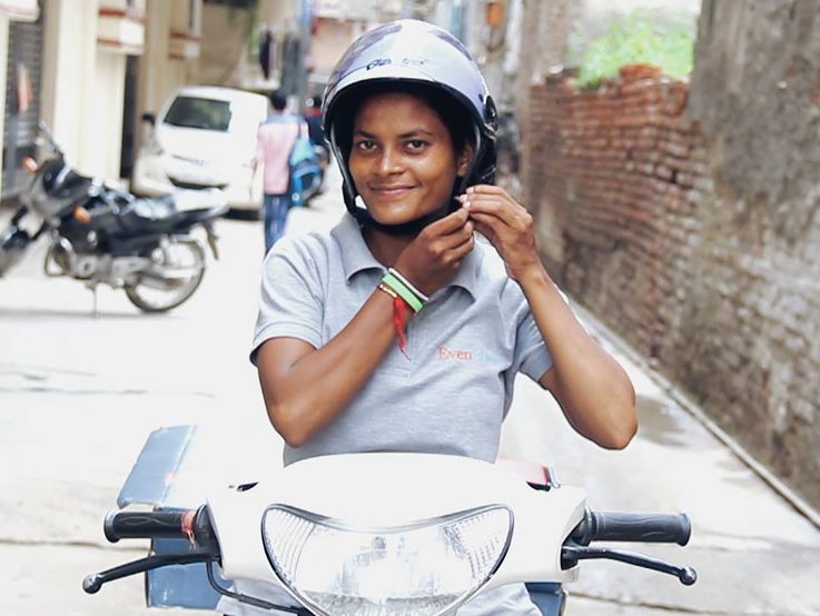 Helmet-wearing, scooter riding delivery girl Sunita