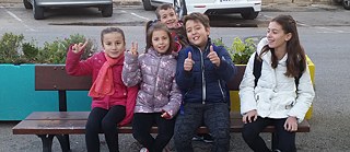 Nine-year-old Elena, with her fellow walkers, on a bench in front of their school.