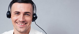 Ein lächelnder Mann mit Kopfhörern
