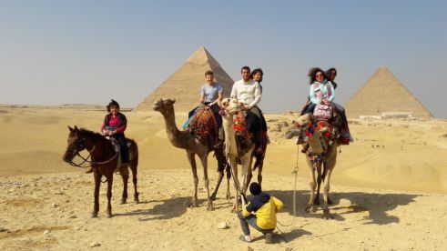 Gruppenfoto auf Kamelen vor den Pyramiden von Gizeh