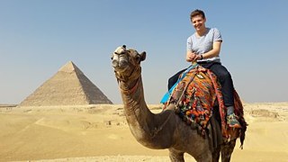 Kamelreitend vor den Pyramiden von Gizeh