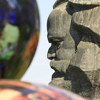 Nahaufnahme des Gesichts eines steinernen Karl-Marx-Denkmals. 