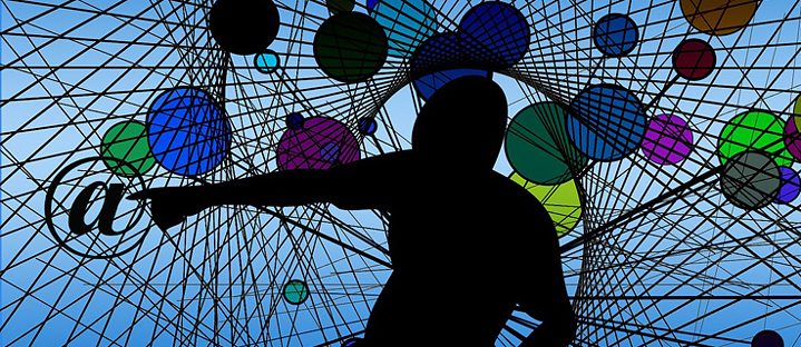 Person in a net is surrounded by colourful balls, points to an @