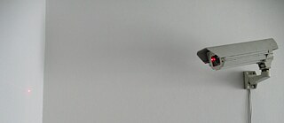 CCTV Kamera, die einen roten Punkt an die Wand beamt