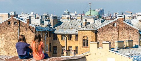 Jugendliche blicken vom Dach aus über eine Stadt