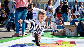 Kleines Mädchen spielt Twister auf der Deutschlandkarte