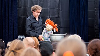 Olaf Möller mit seiner Puppe vor dem Publikum
