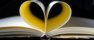 Die Seiten eines aufgeschlagenen Buches formen ein Herz. 