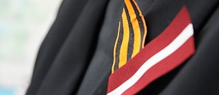 Das Sankt-Georgs-Band und die lettische Fahne – Symbole zweier konkurrierender Erinnerungspraxen in Lettland.