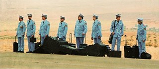 Männer im blauen Anzug mit ihren Instrumenten in der Wüste