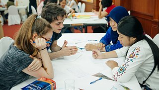 The competition begins. The students have to interview each other about their home countries.