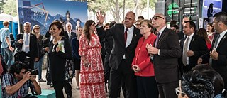 Johannes Ebert shows the Goethe-Infocontainer of the PopUp Tour to the chancellor Angela Merkel