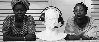 Goethe-Institut Lomé, 1976 – Two students take a short break while the gentleman between them takes care of the equipment