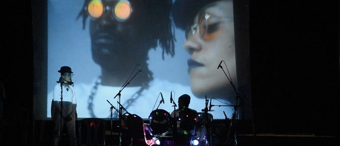 Rachel Nyangombe and Bebson de la Rue on stage at Collège Boboto Kinshasa.