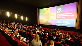 The young people await the start of the next film with anticipation. 
