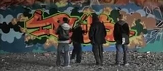 Four people in front of graffiti wall