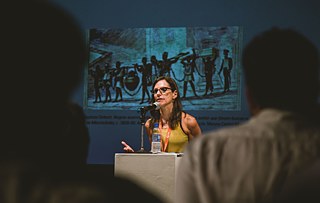 Palestrante mostra quadro imagem que lembra a plateia de acontecimentos atuais: Jean-Baptiste Debret (Negros acorrentados levando para a cadeia o jantar que foram buscar no Hospital da Misericórdia, c. 1820-30) 