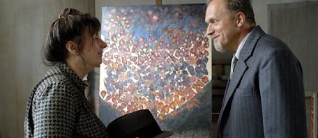 A woman and a man in front of a painting