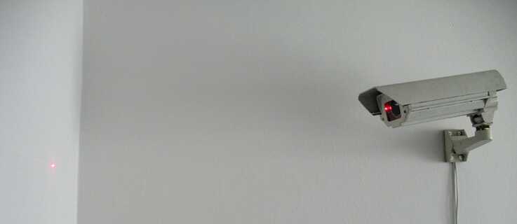 CCTV Kamera, die einen roten Punkt an die Wand beamt