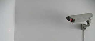 CCTV Kamera, die einen roten Punkt an die Wand beamt