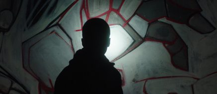 black silhouette in front of graffiti