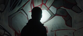 black silhouette in front of graffiti