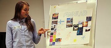 Mädchen präsentiert Plakat zu Finnland