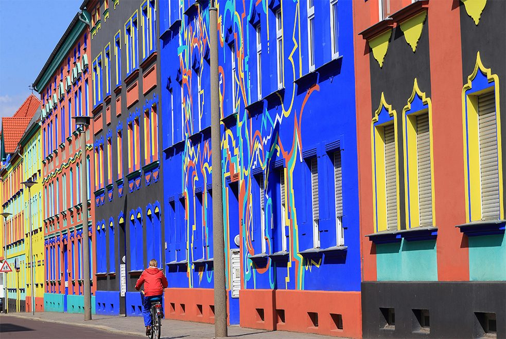 <b>Les bâtiments colorés de Magdeburg</b><br/>Lorsque l'architecte Bruno Taut fut nommé au bureau d'urbanisme de Magdeburg en 1921, il concocta un plan pour donner vie aux murs gris et uniformes de la ville. "La couleur restaurera le caractère des bâtiments", aurait-il dit, avant d'engager des artistes pour repeindre l'hôtel de ville baroque et des blocs de ville entiers dans des couleurs éclatantes. La plupart de ces bâtiments colorés ont été détruits au cours de la Seconde Guerre mondiale, de sorte que les façades conçues par l'architecte et artiste Carl Krayl ont été reconstruites sur la rue  Otto-Richter-Straße.